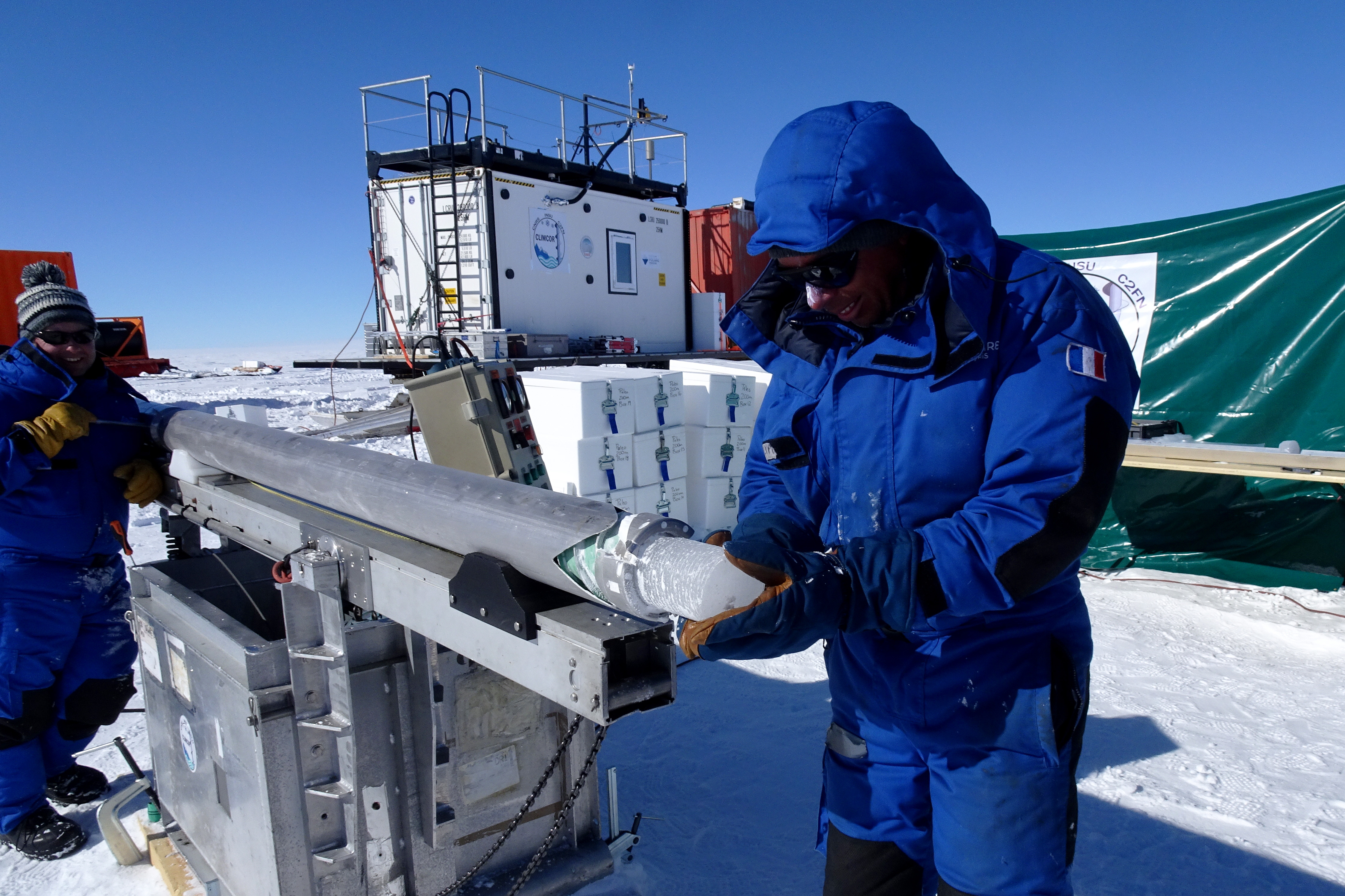 <p>Nicolas Caillon et Philippe Possenti au cours de l'extraction d'une carotte de glace. En arrière fond, le laboratoire chaud (conteneur blanc).<br class='autobr' />
© J Savarino, CNRS/IPEV/PNRA</p>