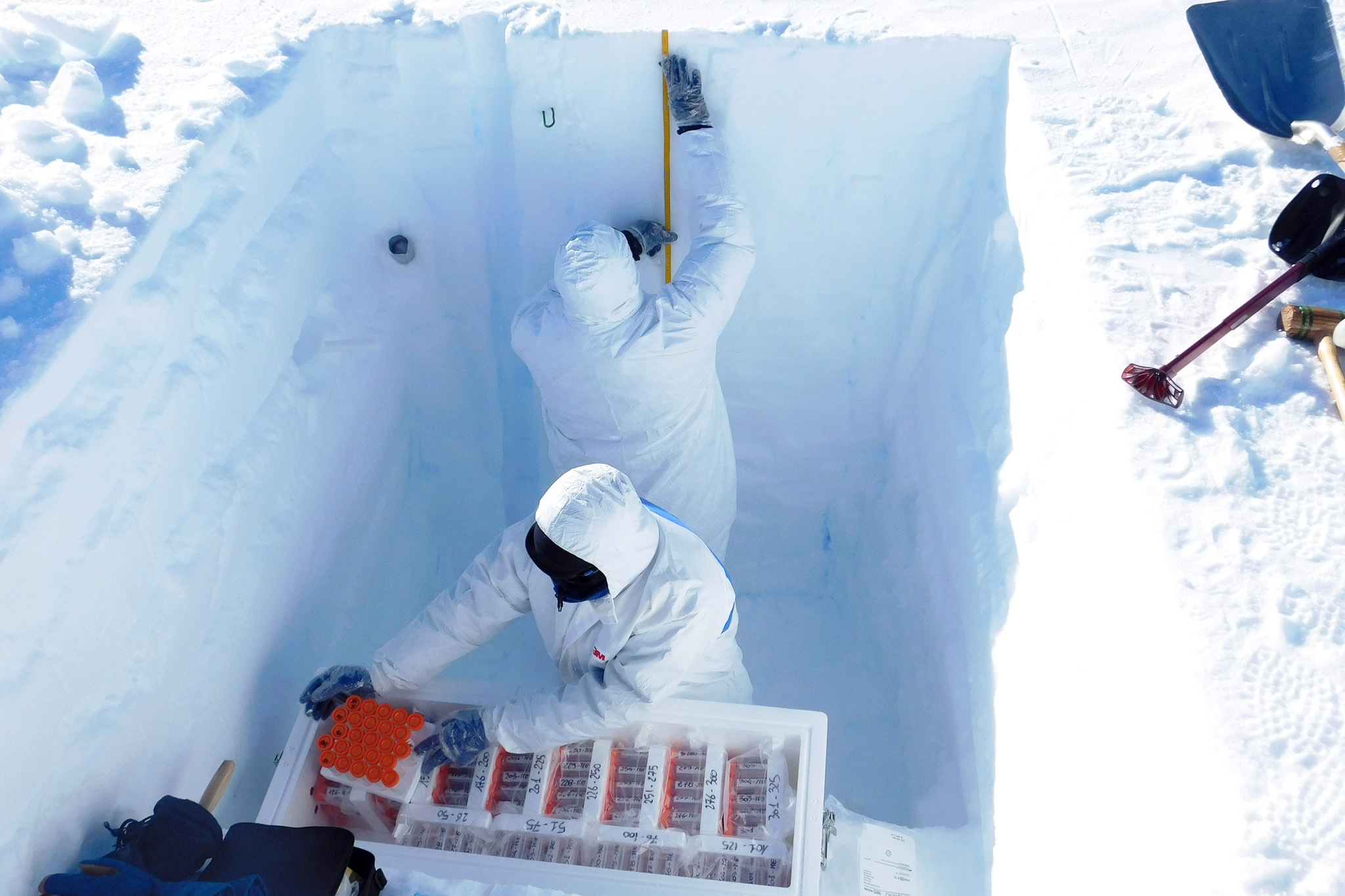 <p>Échantillonnage d'un puits de neige à haute résolution pour l'analyse chimique de la neige. Pour éviter toute contamination de la neige les opérateurs portent des équipement de protection.<br class='autobr' />
© G. Larocca, INGV/IPEV/PNRA</p>